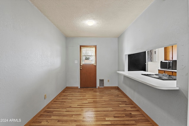 entrance foyer with light hardwood / wood-style flooring and a textured ceiling