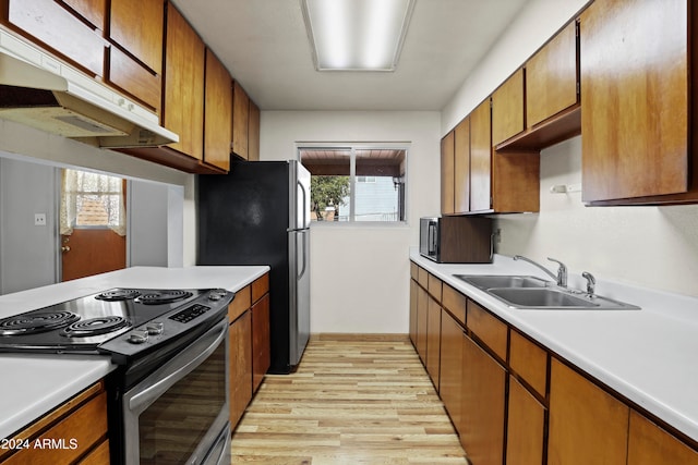 kitchen with sink, stainless steel appliances, and light wood-type flooring