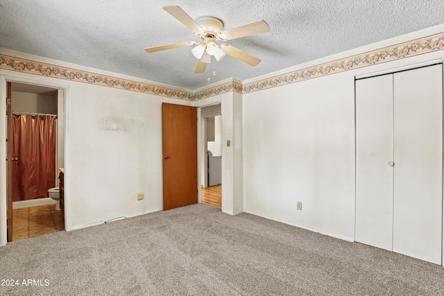 unfurnished bedroom featuring ceiling fan, a textured ceiling, ensuite bathroom, a closet, and light colored carpet