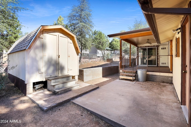 view of patio with ceiling fan and a shed