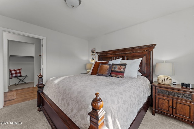 bedroom featuring light colored carpet and a spacious closet