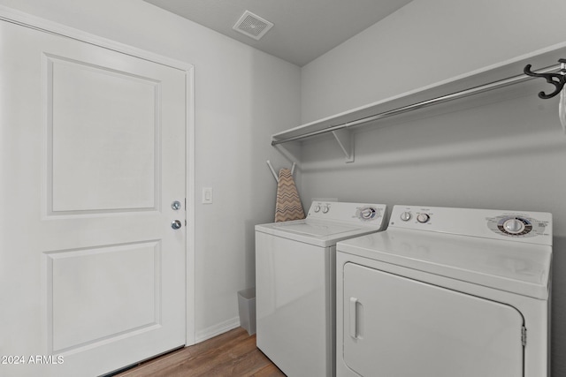 laundry room with washer and dryer and wood-type flooring