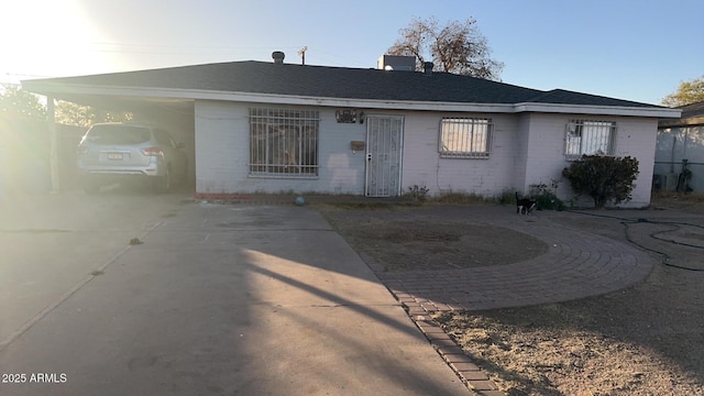 view of front of property with a carport, concrete driveway, and brick siding