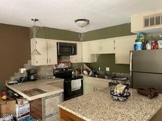 kitchen featuring kitchen peninsula, white cabinetry, black appliances, and light stone counters