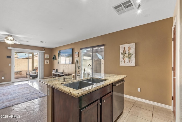 kitchen with dishwasher, sink, ceiling fan, dark brown cabinets, and a center island with sink