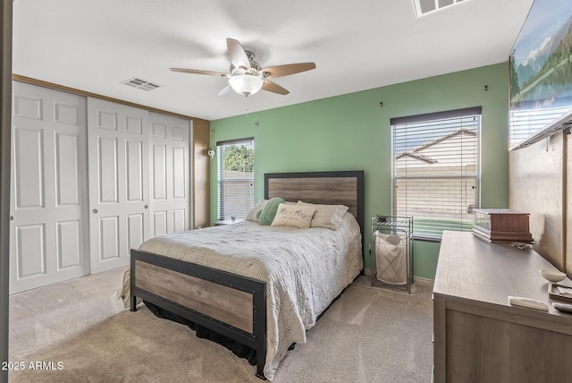 carpeted bedroom with ceiling fan and a closet