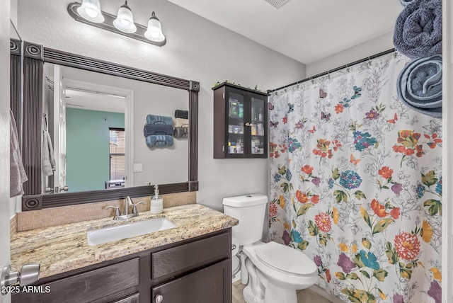 bathroom with vanity, toilet, and curtained shower