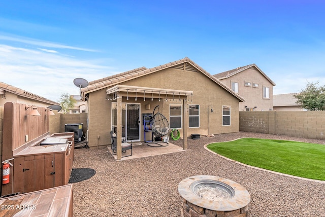 rear view of property featuring a patio, central air condition unit, and an outdoor fire pit