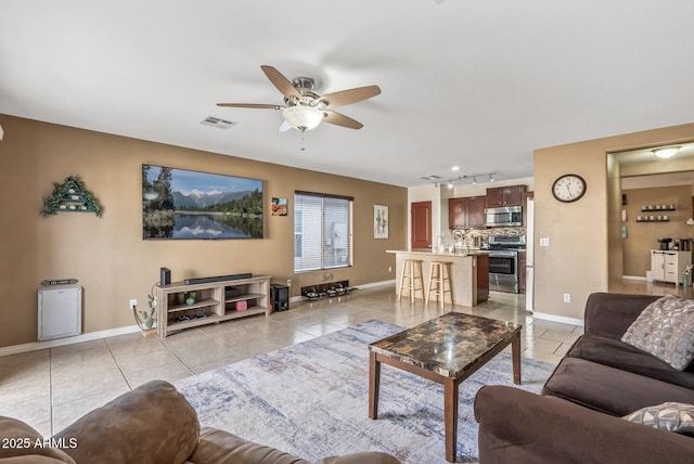 tiled living room with rail lighting and ceiling fan