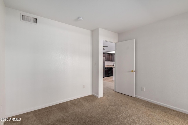 unfurnished room featuring carpet floors, baseboards, and visible vents