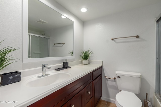 bathroom featuring toilet, a shower with door, visible vents, and vanity