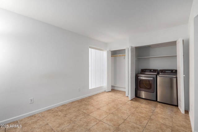 interior space with baseboards, independent washer and dryer, and light tile patterned flooring