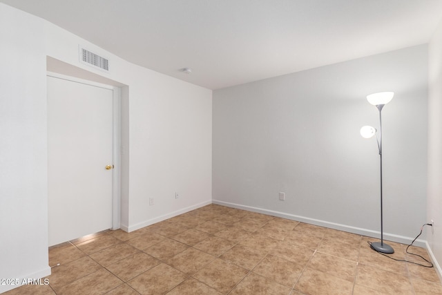 empty room featuring visible vents, baseboards, and light tile patterned floors