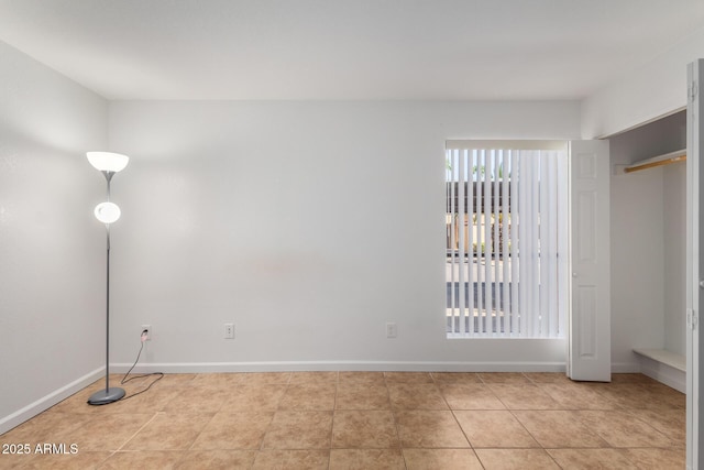 unfurnished bedroom with baseboards and light tile patterned floors