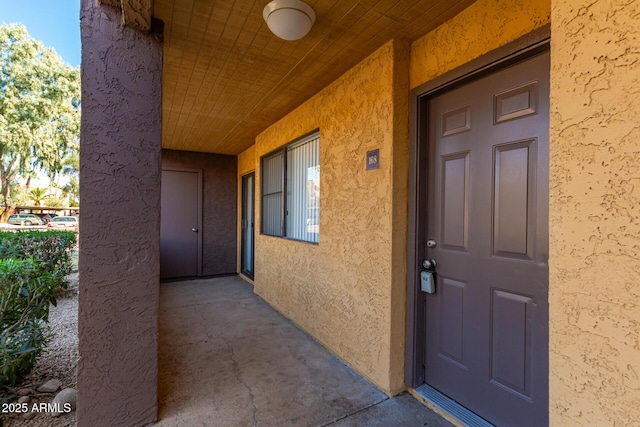 doorway to property featuring stucco siding