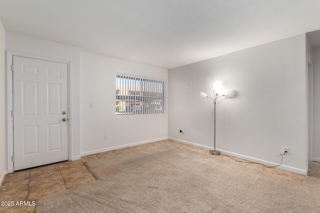 carpeted empty room featuring baseboards