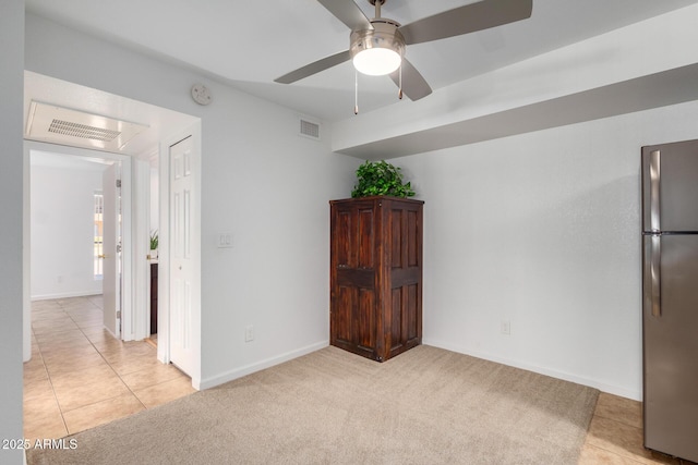 spare room with a ceiling fan, light colored carpet, and visible vents