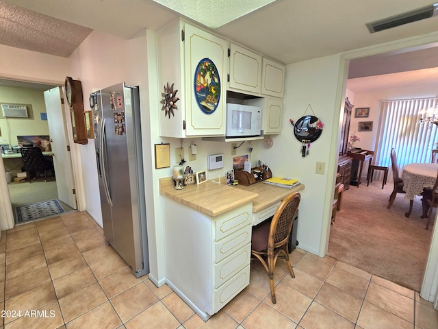 kitchen featuring white cabinets, stainless steel fridge with ice dispenser, light carpet, and a textured ceiling