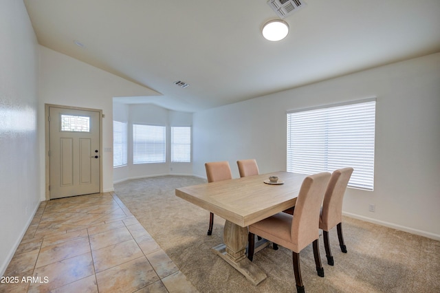 carpeted dining area with lofted ceiling