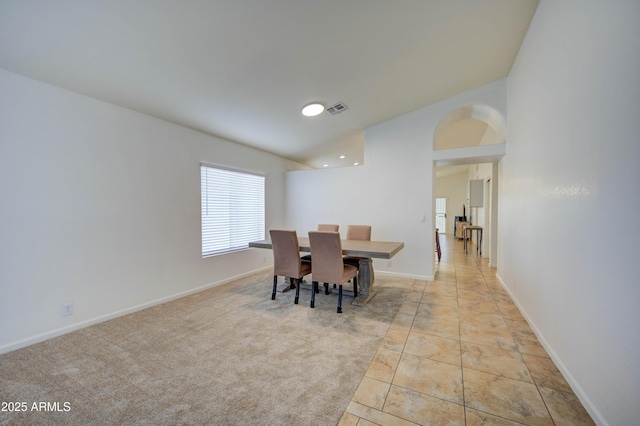 tiled dining area featuring lofted ceiling