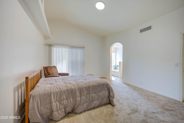 bedroom with vaulted ceiling and light carpet