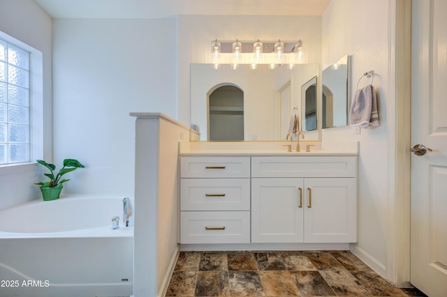 bathroom featuring vanity, a wealth of natural light, and a bathing tub