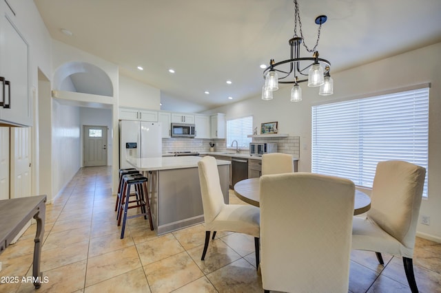 tiled dining space with lofted ceiling