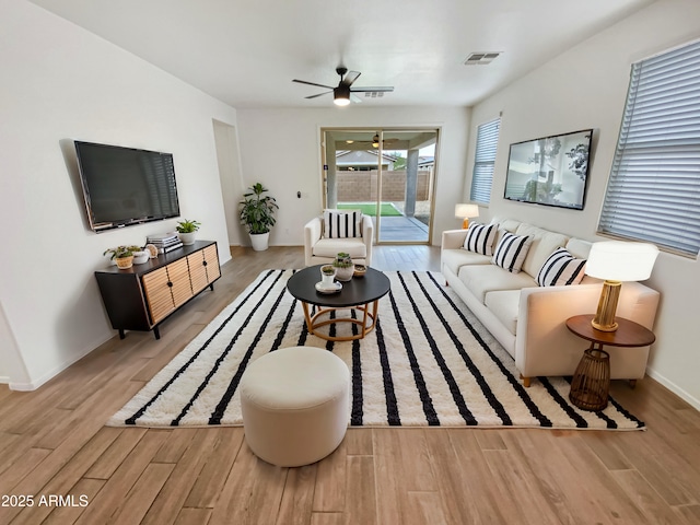 living area featuring ceiling fan, wood finished floors, visible vents, and baseboards