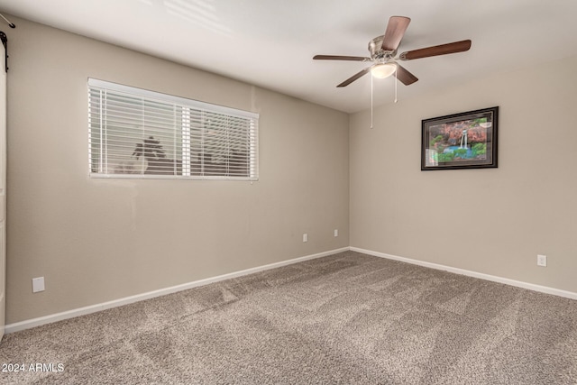 unfurnished room featuring ceiling fan and carpet