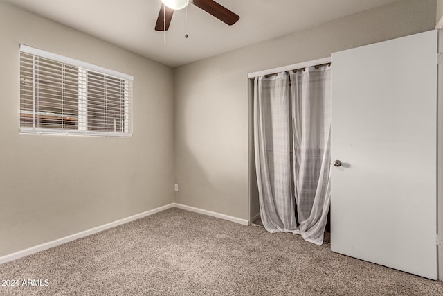 carpeted spare room featuring ceiling fan