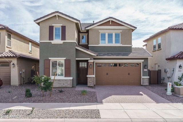 view of front facade with an attached garage, a tiled roof, decorative driveway, and stucco siding