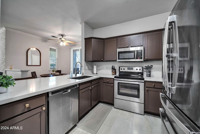 kitchen with stainless steel appliances, kitchen peninsula, sink, and dark brown cabinets