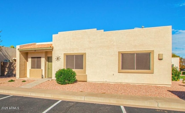 view of front of home featuring uncovered parking and stucco siding