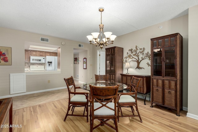 10330 W Thunderbird Blvd Unit C207, Sun City, AZ 85351 - dining space with a chandelier, light wood-type flooring, and a textured ceiling