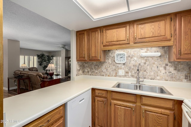 10330 W Thunderbird Blvd Unit C207, Sun City, AZ 85351 - kitchen with white dishwasher, brown cabinetry, light countertops, and decorative backsplash