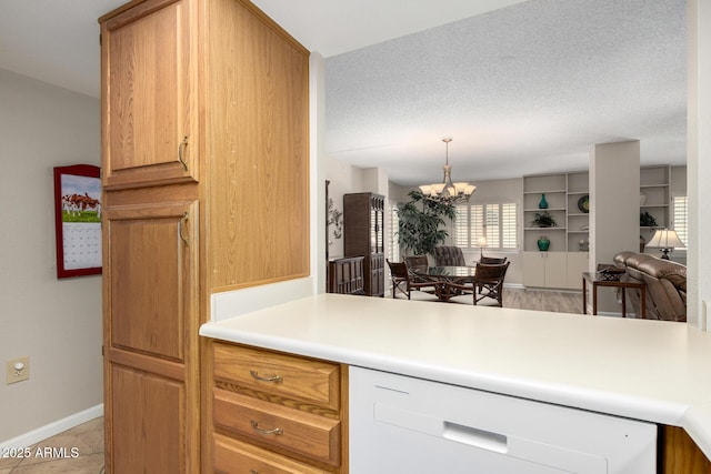 10330 W Thunderbird Blvd Unit C207, Sun City, AZ 85351 - kitchen with white dishwasher, a chandelier, light countertops, open floor plan, and brown cabinets