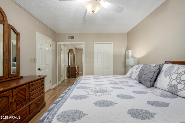 10330 W Thunderbird Blvd Unit C207, Sun City, AZ 85351 - bedroom featuring light wood finished floors, two closets, a textured ceiling, and ceiling fan