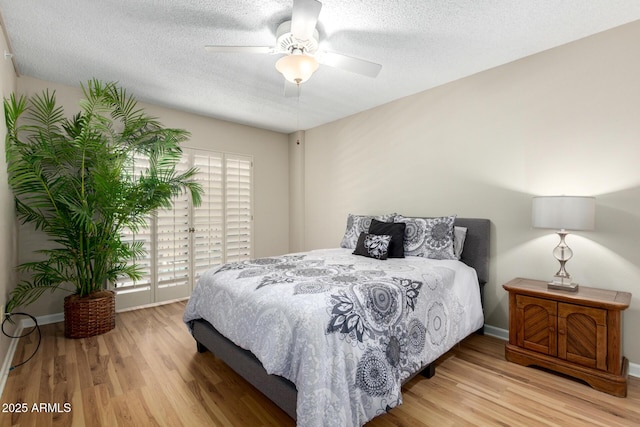 10330 W Thunderbird Blvd Unit C207, Sun City, AZ 85351 - bedroom with wood finished floors, a textured ceiling, and a ceiling fan