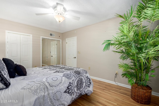 10330 W Thunderbird Blvd Unit C207, Sun City, AZ 85351 - bedroom featuring wood finished floors, a ceiling fan, two closets, and a textured ceiling