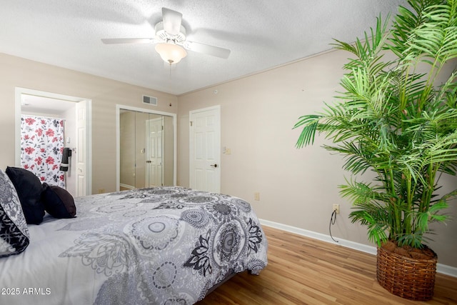 10330 W Thunderbird Blvd Unit C207, Sun City, AZ 85351 - bedroom featuring wood finished floors, a ceiling fan, connected bathroom, and a textured ceiling