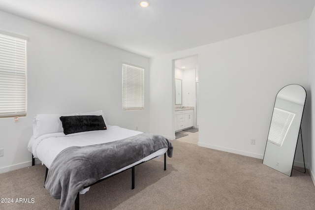 bedroom with baseboards, recessed lighting, ensuite bathroom, and light colored carpet