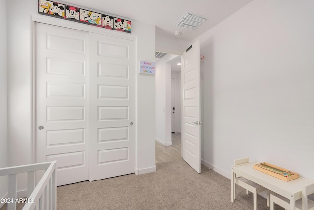 bedroom with light colored carpet, a closet, visible vents, and baseboards