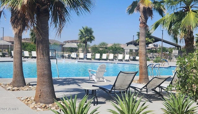 community pool with a patio area and fence