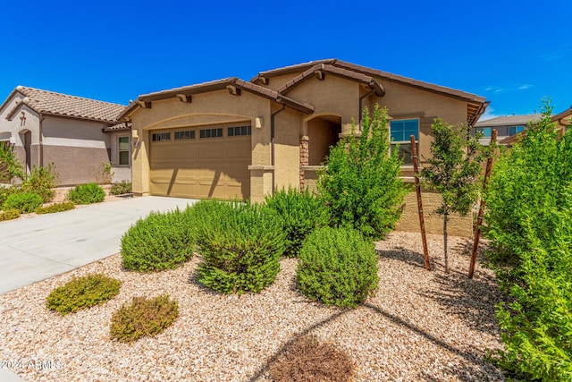 view of front of property featuring a tile roof, driveway, an attached garage, and stucco siding