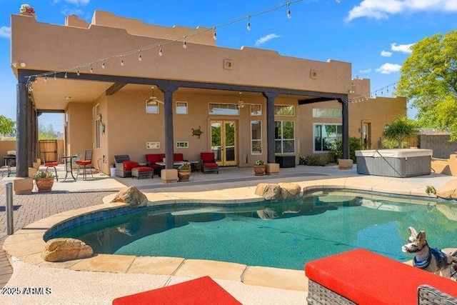 rear view of property with a swimming pool with hot tub and a patio area