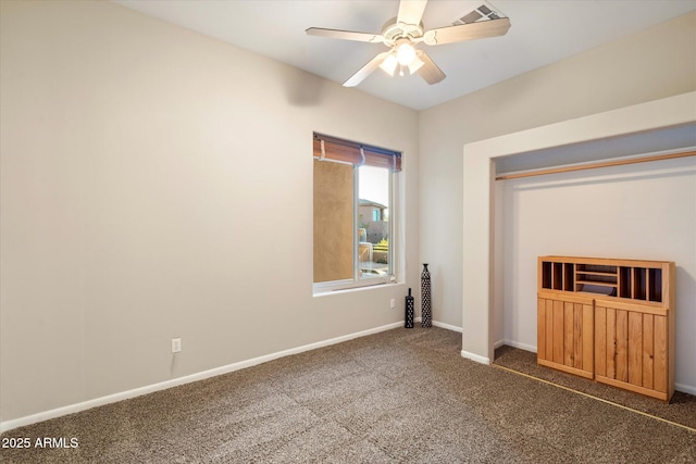 unfurnished bedroom with ceiling fan and dark colored carpet