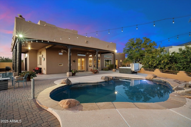 pool at dusk featuring a patio