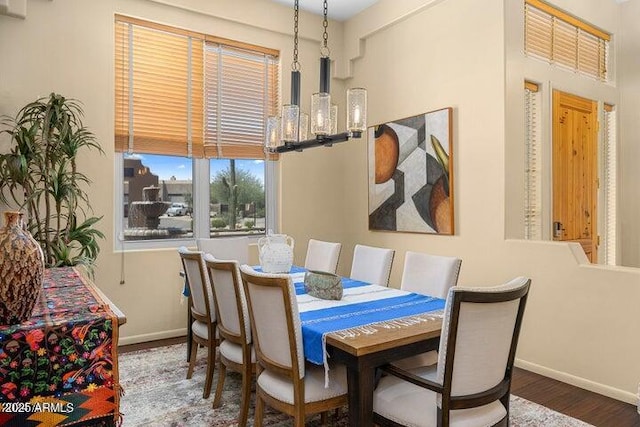 dining area featuring dark wood-type flooring and a notable chandelier