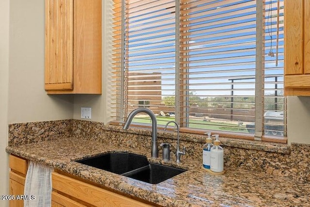 kitchen with stone countertops and sink