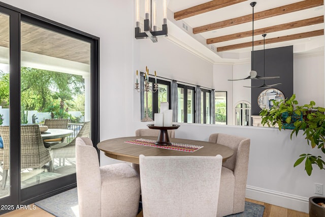 dining room with wood finished floors and beam ceiling